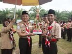 Ketua Kwarda Pramuka 07 Bengkulu, Hamka Sabri menyerah tropy kepada wakil Kabupaten Bengkulu sebagai juara umum lomba Gebyar Kemah Bakti Kwaran Marga Sakti Sebelat, Bengkulu Utara dihelat pekan lalu.(Foto/Ist)