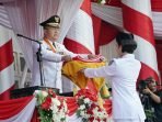 Gubernur Bengkulu, Rohidin Mersyah menyerahkan bendera merah putih kepada salah seorang petugas pengerek bendara pada upacara HUT Kemerdekaan RI ke-77 pada 17 Agustus 2022, bertempat di halaman Balai Raya Semarak Bengkulu.(Foto/Ist)