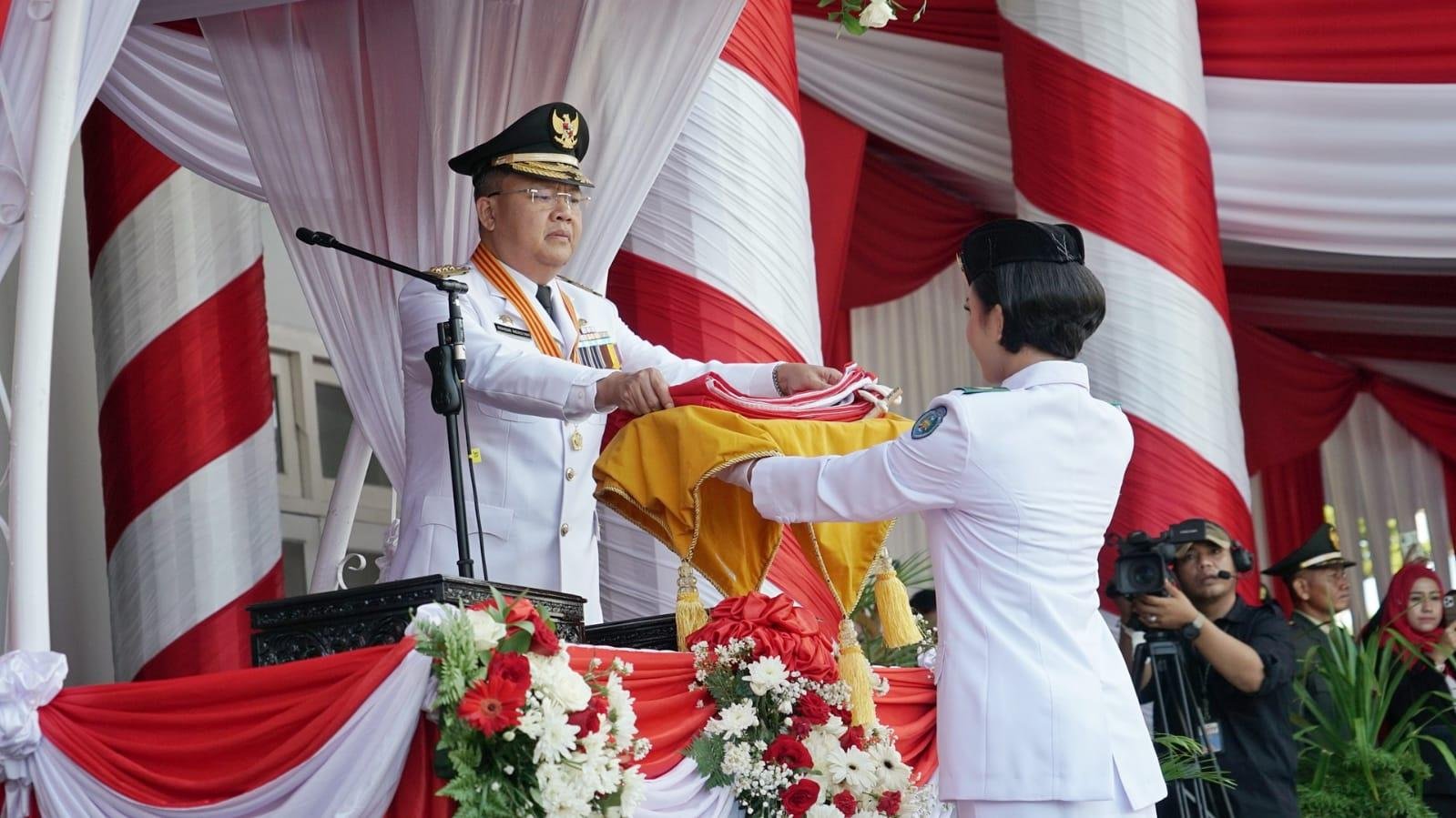 Gubernur Bengkulu, Rohidin Mersyah menyerahkan bendera merah putih kepada salah seorang petugas pengerek bendara pada upacara HUT Kemerdekaan RI ke-77 pada 17 Agustus 2022, bertempat di halaman Balai Raya Semarak Bengkulu.(Foto/Ist)