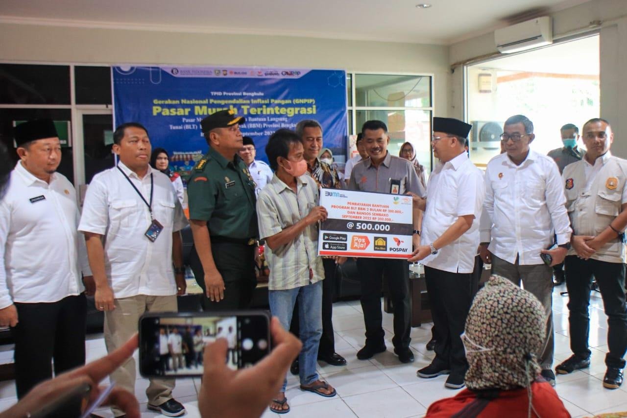 Gubernur Bengkulu, Rohidin Mersyah disaksikan Asisten II Pemprov Bengkulu, Fachriza Razie (paling kiri), dan pejabat lainya menyerahkan dana bantuan langsung tunai (BLT) BBK kepada masyarakat kelompok penerima manfaat (KPM) di Kota Bengkulu, bertempat di Kantor Cabang Utama PT Pos Indonesia wilayah Bengkulu.(Foto/Ist)