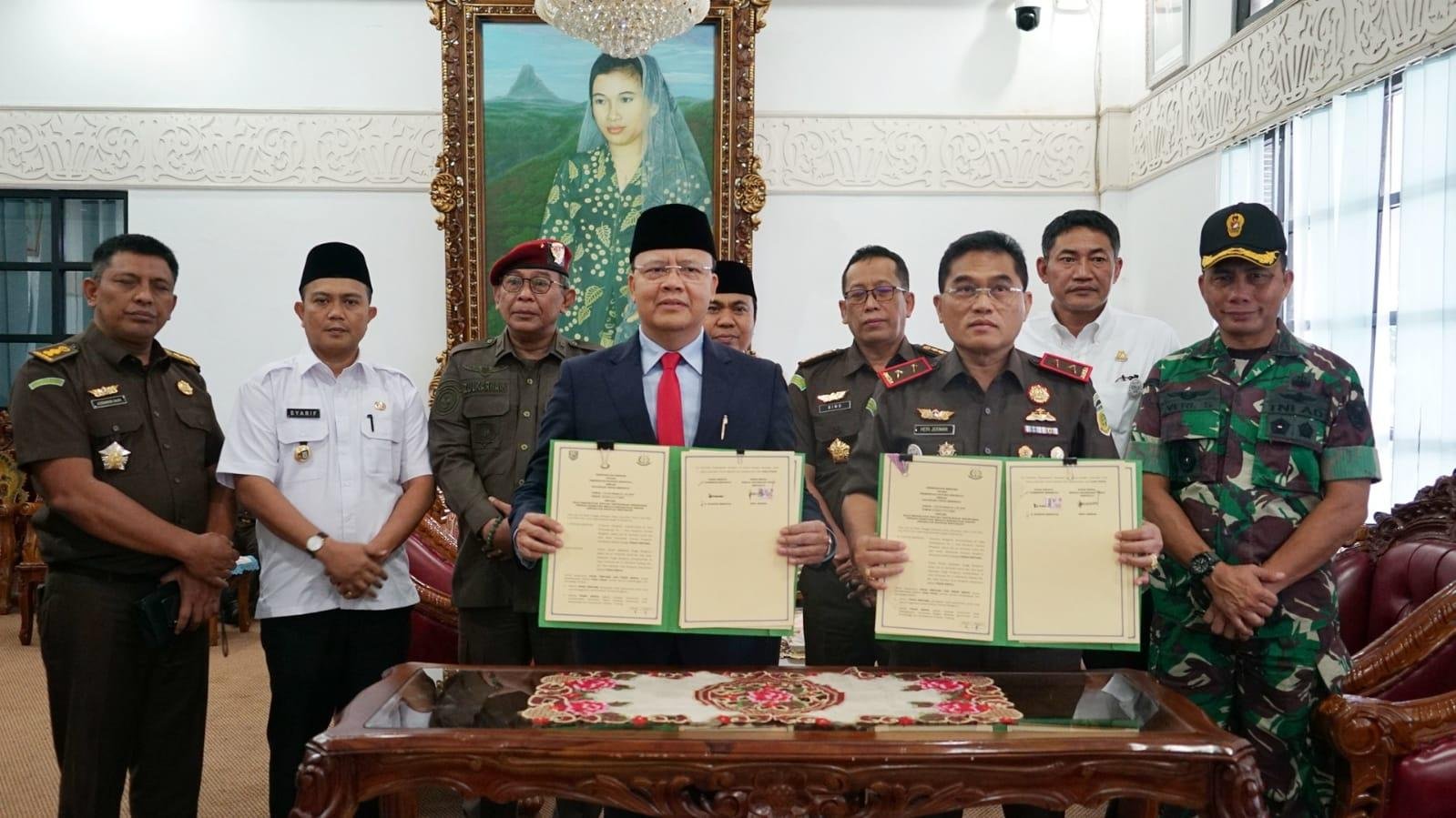 Gubernur Bengkulu, Rohidin Mersyah dan Kejati Bengkulu, Heri Jerman foto bersama disaksikan pejabat terkait usia melakukan penandatangan naskah kerja sama dalam hal penanganan kasus narkoba pemakai di Bengkulu.(Foto/Ist)