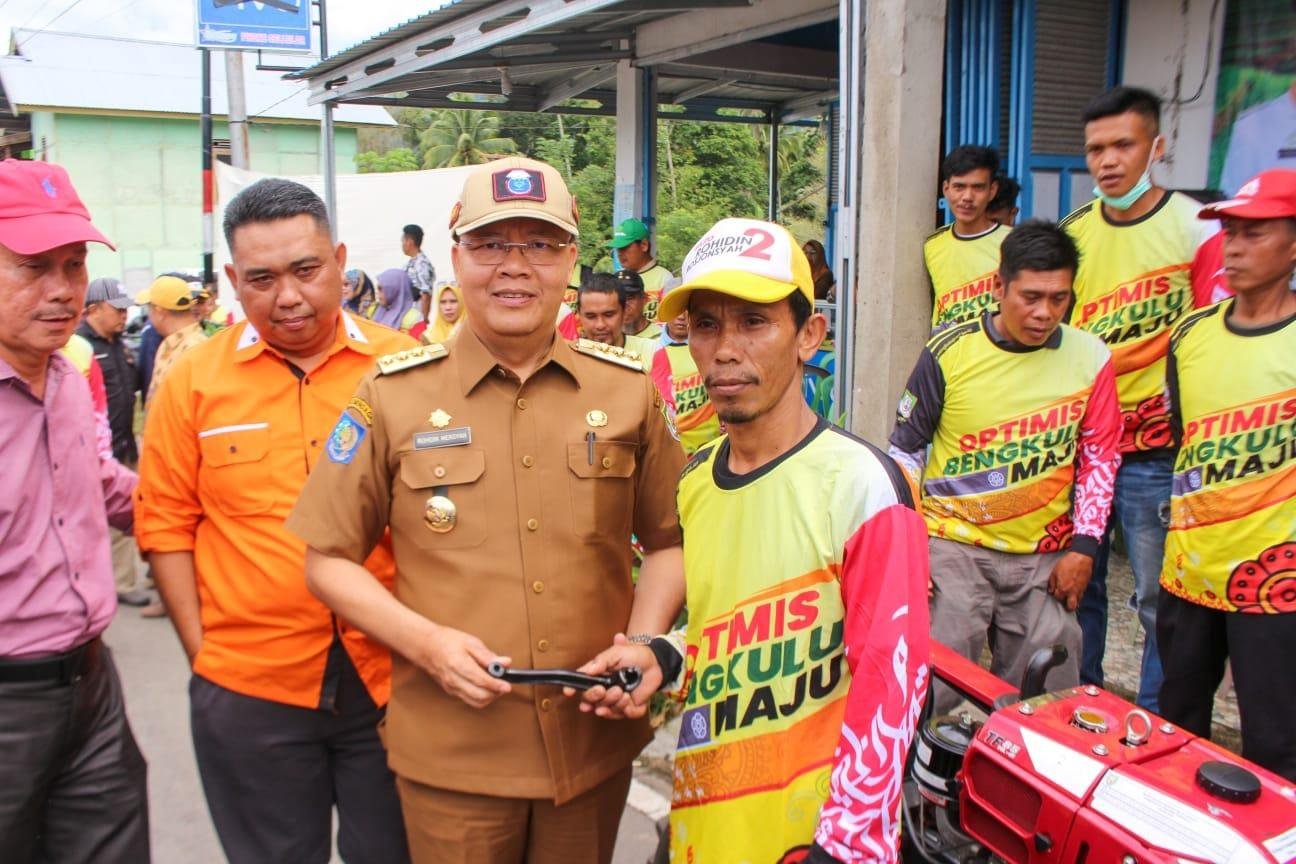 Serahkan Bantuan Alsintan di Lebong Gubernur Bengkulu, Rohidin Mersyah disaksikan Kepala Dins Tanaman Pangan, Holtikultura dan Perkebunan (TPHP) Provinsi Bengkulu, Ricky Gunarwan (paling kiri) menyerahkan bantuan Alsintan berupa hand traktor (traktor tangan) kepada kelompok tani di Desa Talang Leak, Kabupaten Bingin Kuning, Kabupaten Lebong.(Foto/Ist)