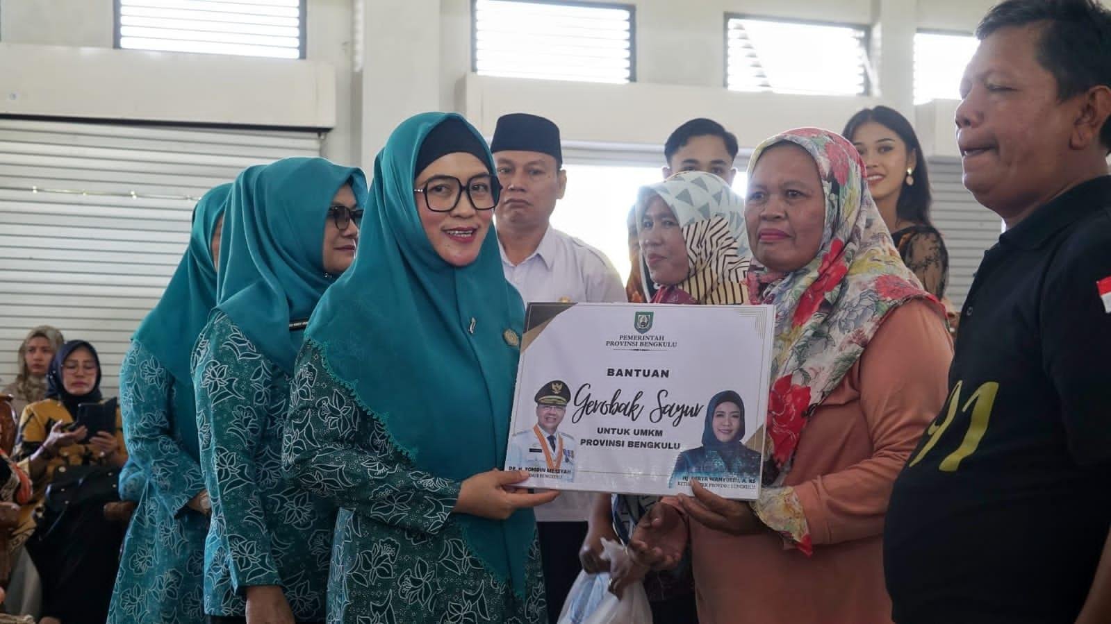 Ketua TP PKK Provinsi Bengkulu, Derta Wahyulin Rohidin menyerahkan bantuan gerobak sayur kepada salah seorang pedagang sayur keliling fi Kabupaten Kaur. Bantuan ini diberikan dalam rangka meningkatkan kesejahteraan masyarakat, khususnya bagi penerima bantuan tersebut.(Foto/Ist)