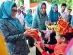 Ketua TP PKK Provinsi Bengkulu, Derta Wahyulin Rohidin dan rombongan menerima bunga dari seorang anak kecil saat tiba di acara pembinaan 10 Program PKK di Bengkulu Utara.(Foto/Ist)