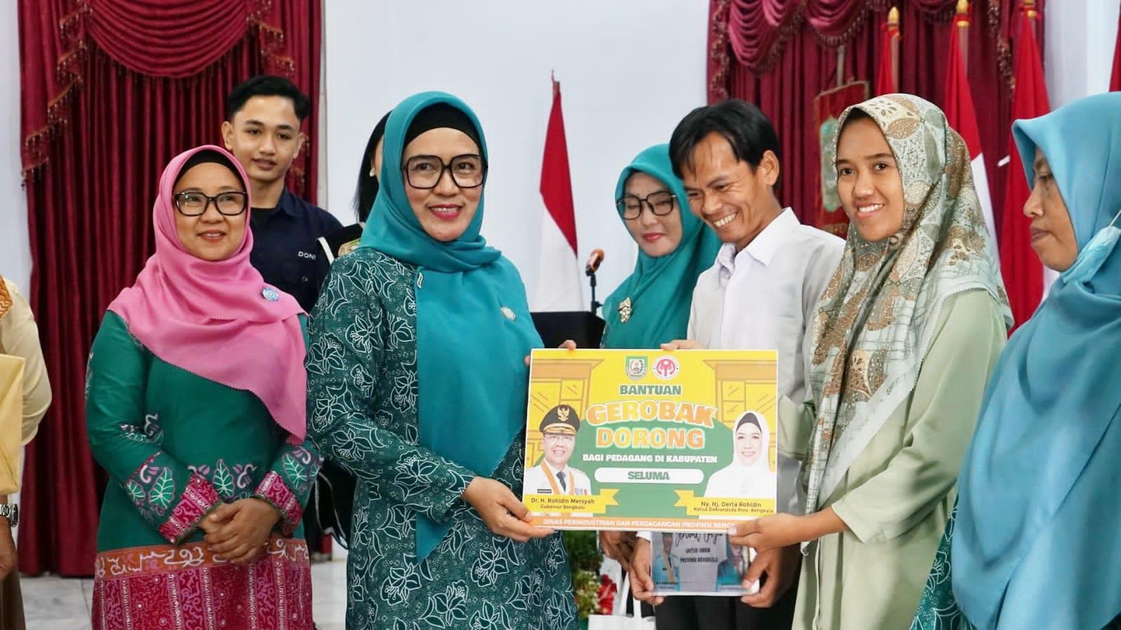 PKK Bantuan Gerombak Dorong Ketua TP PKK Provinsi Bengkulu, Derta Wahyulin Rohidin menyerahkan bantuan kerobak dorong kepada salah seorang pelaku UMKM di Kabupaten Seluma. Bantuan ini diberikan dalam rangka pembinaan 10 program PKK di Seluma.(Foto/Ist)