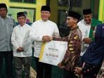 Bantuan Masjid Mukomuko Gubernur Bengkulu, Rohidin Mersyah disaksikan Bupati Mukomuko, Sapuan (kedua dari kiri) menyerahkan bantuan masjid kepada salah seorang pengurus masjid di Kabupaten Mukomuko senilai Rp 50 juta. Bantuan ini disampaikan Gubernur Rohidin dalam lawatan Safari Ramadan ke Kabupaten Mukomuko awal pekan ini.(Foto/Ist)