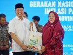Gubernur Bengkulu, Rohidin Mersyah menyerahkan bingkisan pangan kepada salah seorang peserta rapat koordinasi ketahanan pangan di Balai Raya Semarak Bengkulu.(Foto/Ist)