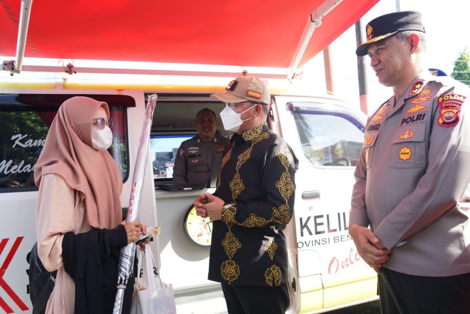 Gubernur Bengkulu, Rohidin Mersyah didampingi Kapolda Bengkulu, Irjen Pol Armed Wijaya bincang-bincang dengan salah seorang warga tengah membayar pajak kendaraan bermotor di mobil samsat keliling.(Foto/Ist)