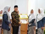 Gubernur Bengkulu, Rohidin Mersyah menyerahkan hadiah kepada pemenang lomba paduan suara dalam rangka merayakan HUT IBI ke-77 Tahun 2023.(Foto/Ist)