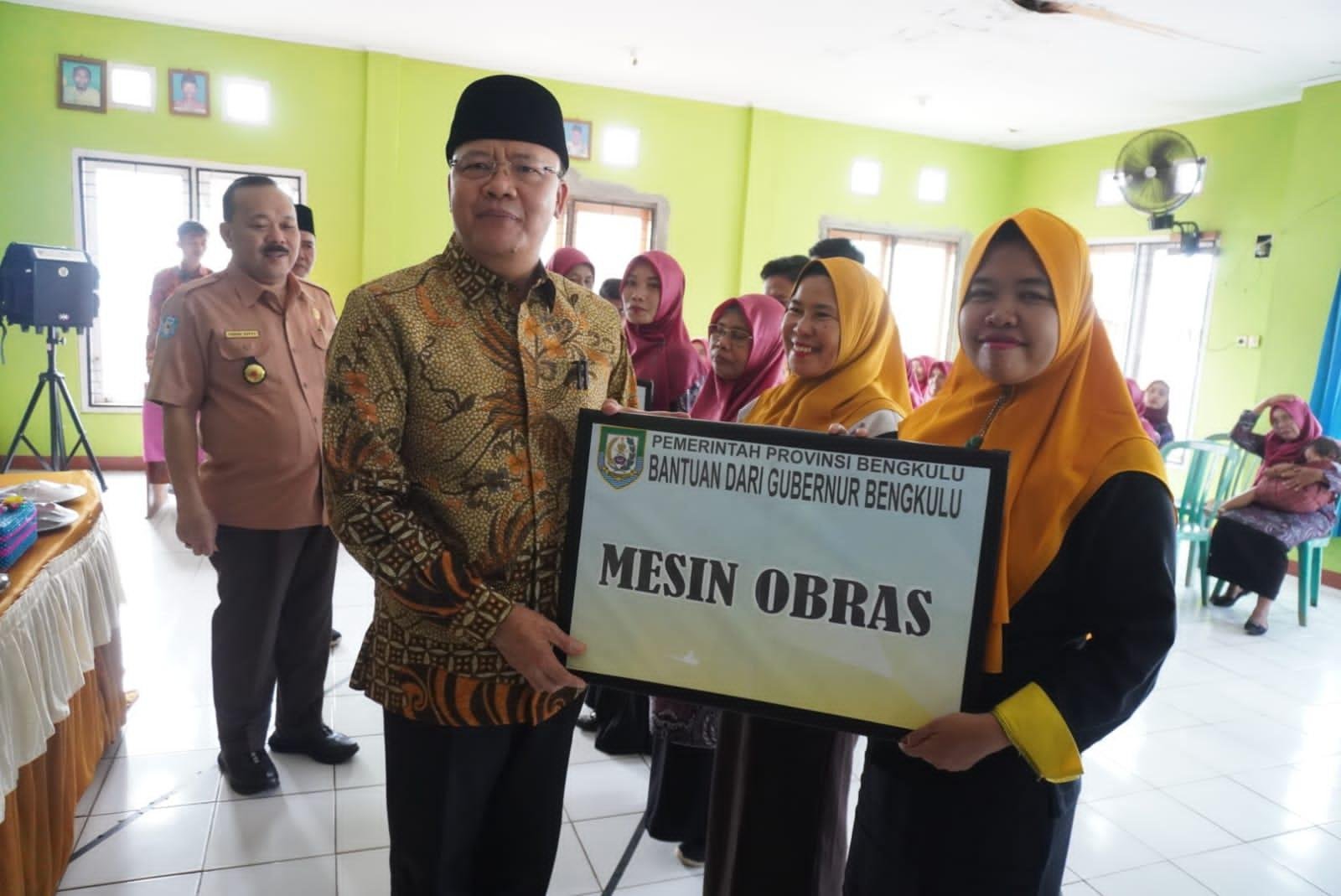 Gubernur Bengkulu, Rohidin Mersyah disaksikan Kepala Disnaker Bengkulu, Edwar Hepy menyerahkan bantuan alat kerja berupa mesin jahit kepada kelompok usaha PKK Desa Srikaton, Kecamatan Pondok Kelapa, Kabupaten Bengkulu Tengah.(Foto/Ist)