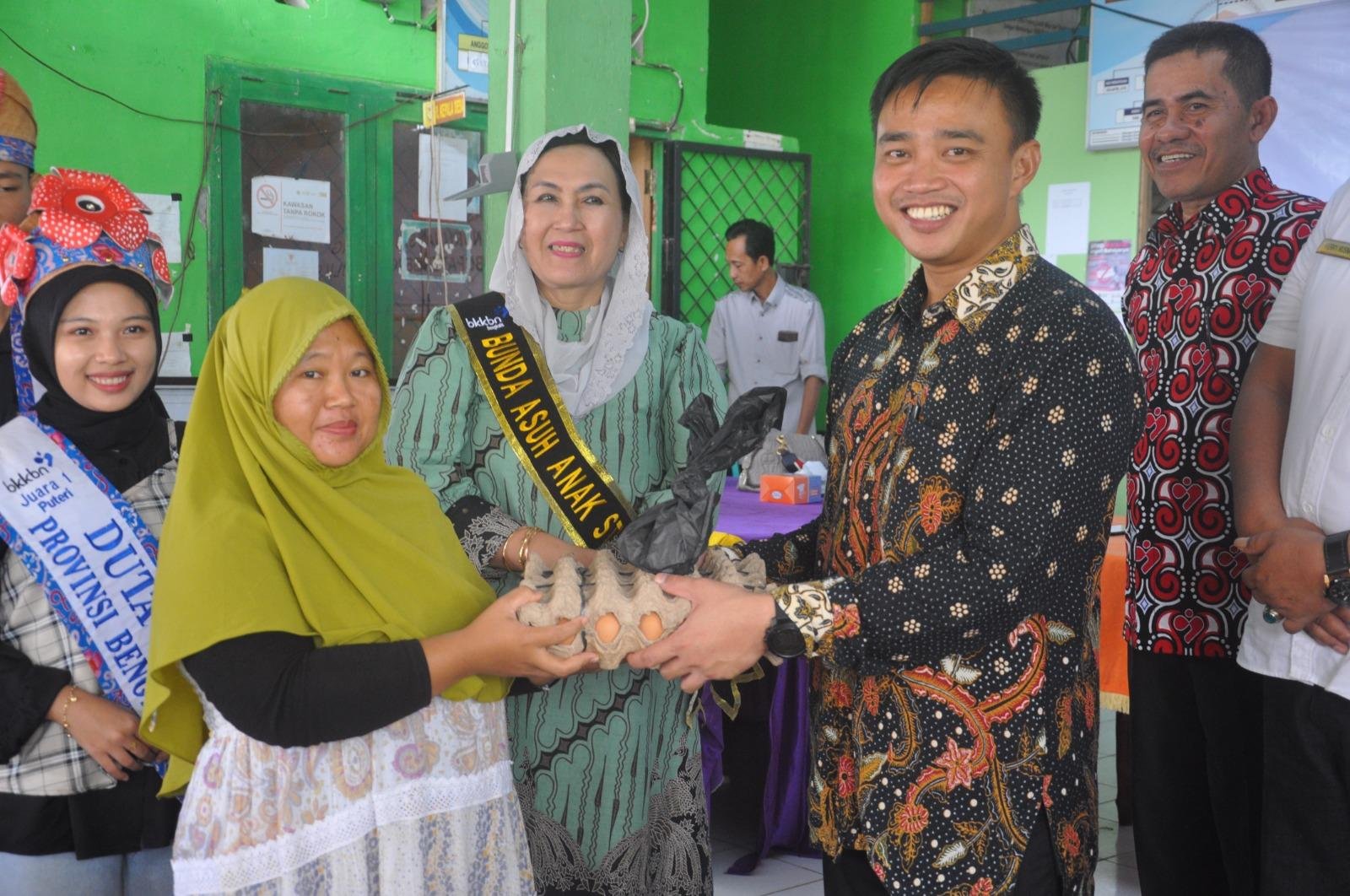 Plt Kepala BKKBN Bengkulu, Iqbal Apriansyah disaksikan anggota Komis IX DPR-RI dapil Benngkulu, Elva Hartati saat menyerahkan bantuan telur kepada salah seorang ibu yang memilik anak dibawah 2 tahun saat menggelar sosialisasi stunting di Bengkulu Selatan.(Foto HB/Idris)