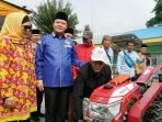 Gubernur Rohidin Mersyah disaksikan Ketua TP PKK Provinsi Bengkulu, Derta Rohidin dan Plt Kepala Dinas TPHP Bengkulu, Rosmala Dewi menyaksikan seorang petani mencoba menghidupkan handraktor bantuan dari Pemprov Bengkulu, usai penyerahan alsintan kepada sejumlah kelompok tani di Kabupaten Lebong, akhir pekan lalu.(Foto/Ist)