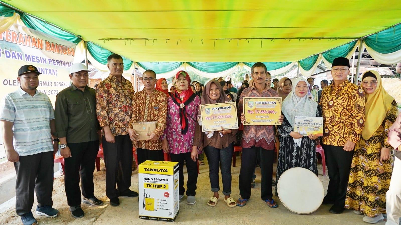 Gubernur Bengkulu, Rohidin Mersyah dan Ketua TPP PKK Provinsi Bengkulu, Derta Rohidin (paling kanan) foto bersama masyarakat usia menyerahkan bantuan Alsintan, alat kesenian dan bedah rumah di Bengkulu Tengah.(Foto/Ist)
