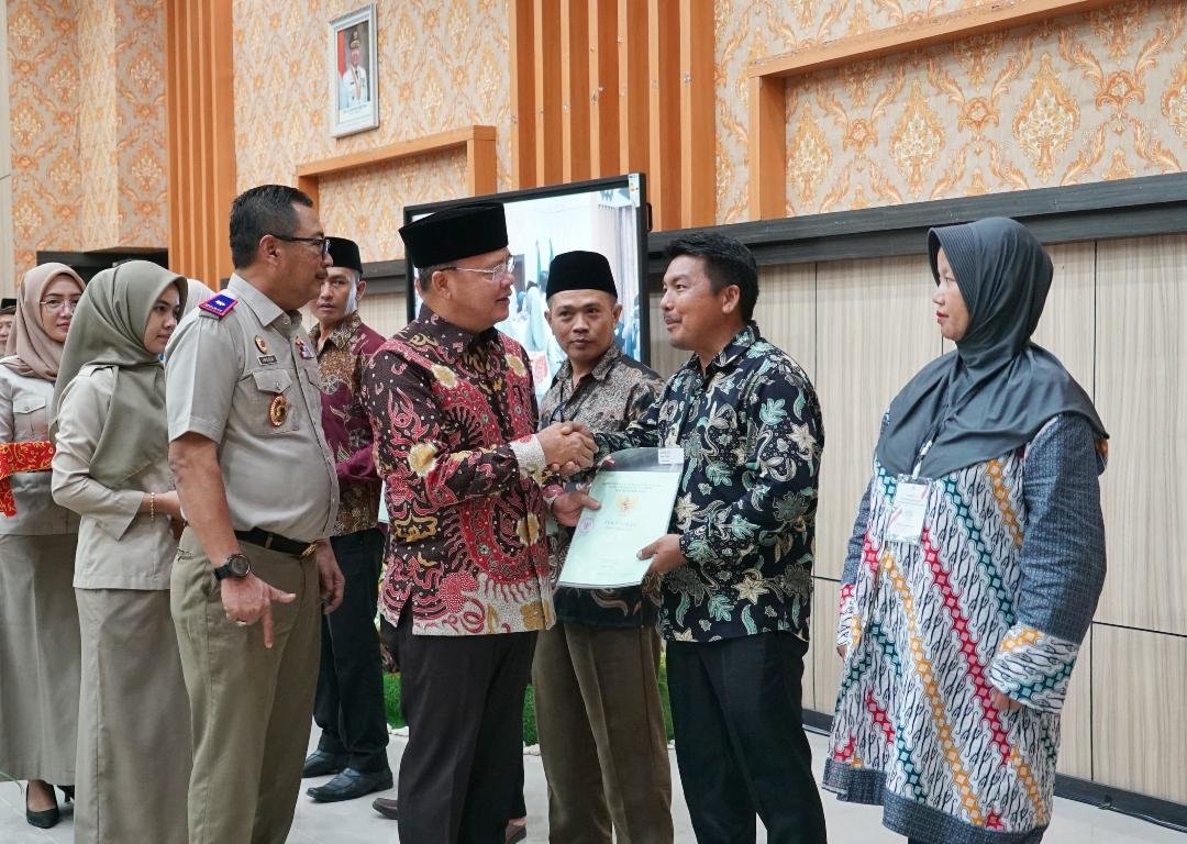 Gubernur Bengkulu, Rohidin Mersyah disaksikan Kepala BPN Bengkulu, Indera Imanuddin menyerahkan sertifikat tanah PTSL kepada warga Bengkulu, bertempat di kantor Gubernur Bengkulu, awal pekan ini.(Foto/Ist)