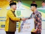 Gubernur Bengkulu Rohidin Mersyah menyerahkan bantuan dana hibah dari Pemprov Bengkulu kepada Pengurus TP Sriwijaya setempat.(Foto/Ist)