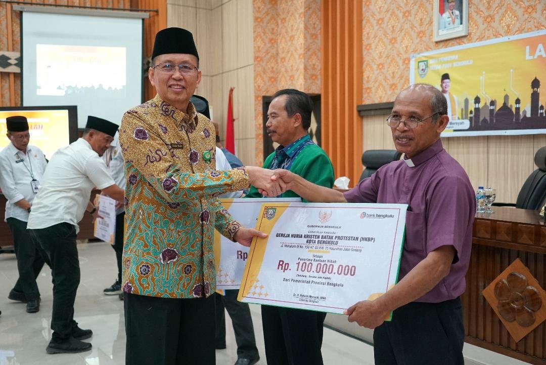 Sekdaprov Bengkulu, Isnan Fajri menyerahkan bantuan danah hibah Pemprov Bengkulu kepada sejumlah penerima seusai melauching sistem sistem informasi laporan hibah.(Foto/Ist)