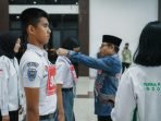 Asisten I Pemprov Bengkulu, Khairil Anwar mengalungkan tanda peserta kepada salah seorang pesarta seleksi anggota Paskibraka tingkat Provinsi Bengkulu tahun 2024.(Foto/Pemprov Bengkulu)