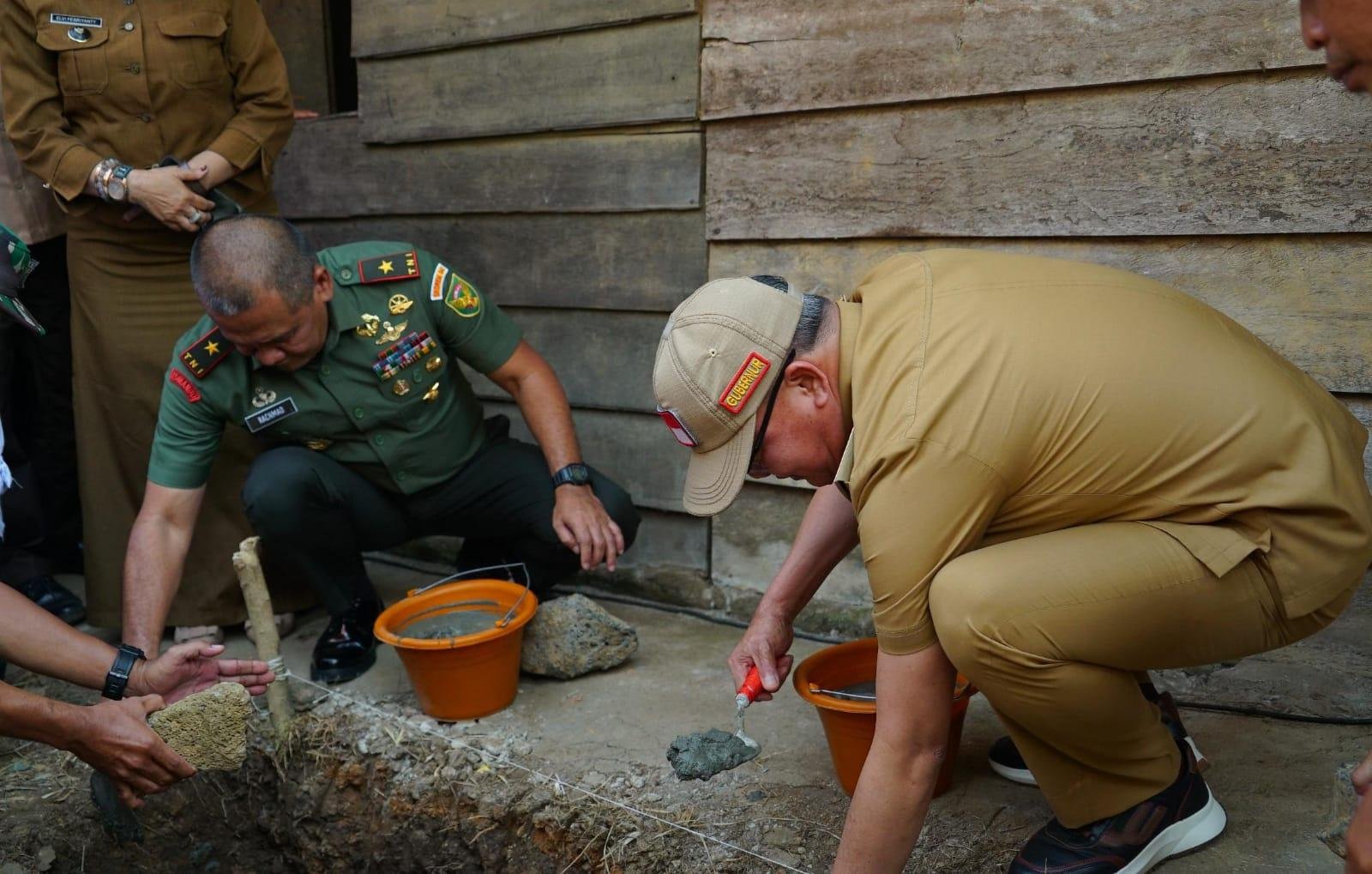 Gubernur Bengkulu Rohidin Meryah dan Damrem 041 Gamas Brigjen TNI Rachmad Zulkarnaen melatekan batu program rumah tidak layak huni (RTLH) di Desa Nakau, Kecamatan Talang Empat, Bengkulu Tengah.(Foto/Humas Pemprov Bengkulu)