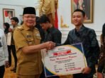 Serahkan Beasiswa Kerua Osis Gubernur Bengkulu Rohidin Mersyah menyerahkan bantuan beasiswa untuk Ketua Osis SMA/SMK/MA se- Provinsi Bengkulu, bertempat di Balai Raya Semarak Bengkulu, Rabu tanggal 24 Juli 2024.(Foto : Humas Pemprov Bengkulu)