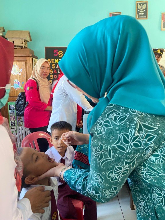 Penjabat Ketua TP PKK Kabupaten Benteng, Dian Heri Roni meneteskan vaksin polio kepada salah seorang anak di Posyandu Desa Nakau, Kecamatan Takang Empat, Senin 27 Juli 2024.(Foto : Humas Pemkab Benteng)