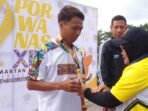 Pengalungan medali perak atlet siwo pwi bengkulu. Alpinda Nopra pada cabor atletik lari 5.000 meter,