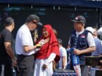 Gubernur Bengkulu, Rohidin Mersyah memberikan hadiah umroh kepada salah satu peserta jalan santai yang beruntung, Minggu 8 Agustus 2024.(Foto-Humas Pemprov Bengkulu)