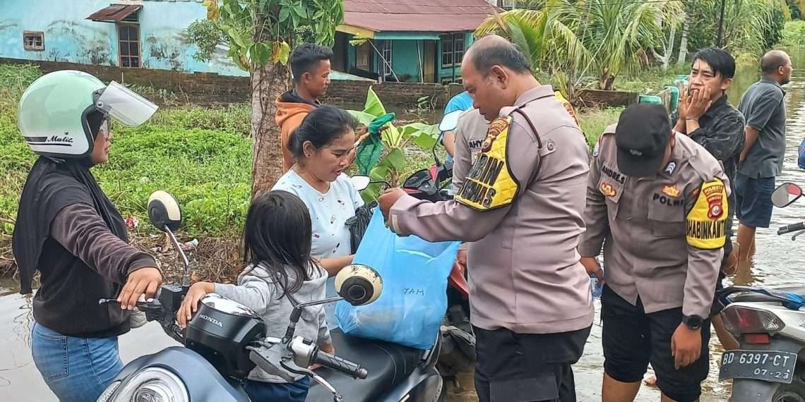 Anggota Polsek Ratu Agung, Kota Bengkulu menyalurkan bantuan pangan kepada warga terdampak banjir, Selasa 3 Desember 2024.(Foto-RRI)
