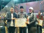Award KIPD Bengkulu Plt Gubernur Bengkulu, Rosjosyah menyerahkan hadiah kepada salah satu lembaga penyiar terbaik di Bengkulu pada malam Award KIPD Bengkulu tahun 2024, Minggu 8 Desember 2024.(Foto-Humas Pemprov Bengkulu)