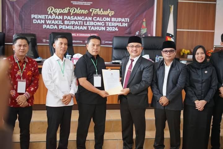 Ketua KPU Lebong, Yoki Setiawan menyerahkan SK kepada Zahari-Bambang sebagai bupati-wabup Lebong terpilih seusai menggelar rapat pleno, Kamis 9 Desember 2024.(Foto/Istimewa)