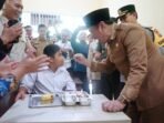 Suaokan Nasi pada siswa SLB Plt Gubernur Bengkulu, Rosjosnyah menyuapkan nasi kepada salah satu siswa SD saat meninjau pelaksanaan program BMG di SDN 1 SLB Kota Bengkulu, Senin 17 Februari 2025.(Foto-MC Bengkulu)