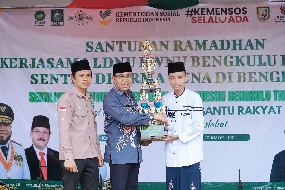 Serahkan Piala STIENUS Asisten I Pemprov Bengkulu, Khairil Anwar menyerahkan piala kepada pemenang lomba kegiatan dalam rangka Dies Natalis ke-9, STIESNU Bengulu.(Foto-MC Bengkulu)