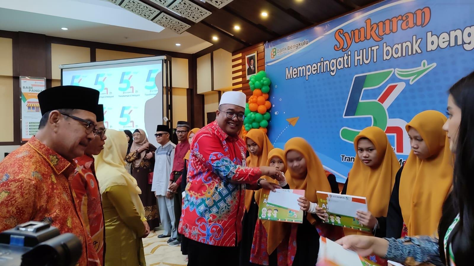 Plt Direktur Utama (Dirut) Bank Bengkulu, Iswahyudi menyerahkan santunan kepada anak yatim pada acara bakti sosial dalam rangka memperingati HUT ke-54 Bank Bengkulu, Senin 14 April 2025.(Foto/ Humas Bank Bwngkulu)