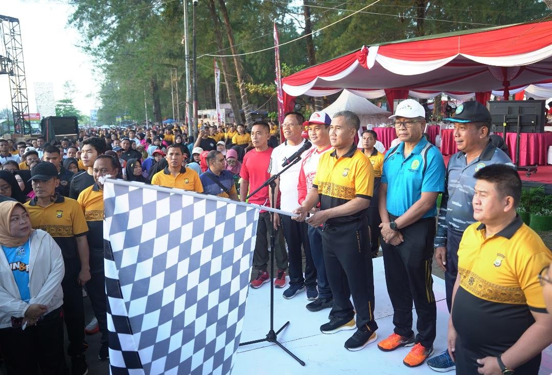 Kapolda Bengkulu Irjen Pol Mardiyono mengangkat bendera melepas peserta jalan sehat HUT Bhayangkara ke-79 di Pantai Panjang, Kota Bengkulu, Minggu 22 Juni 2025.(Foto/Ist)