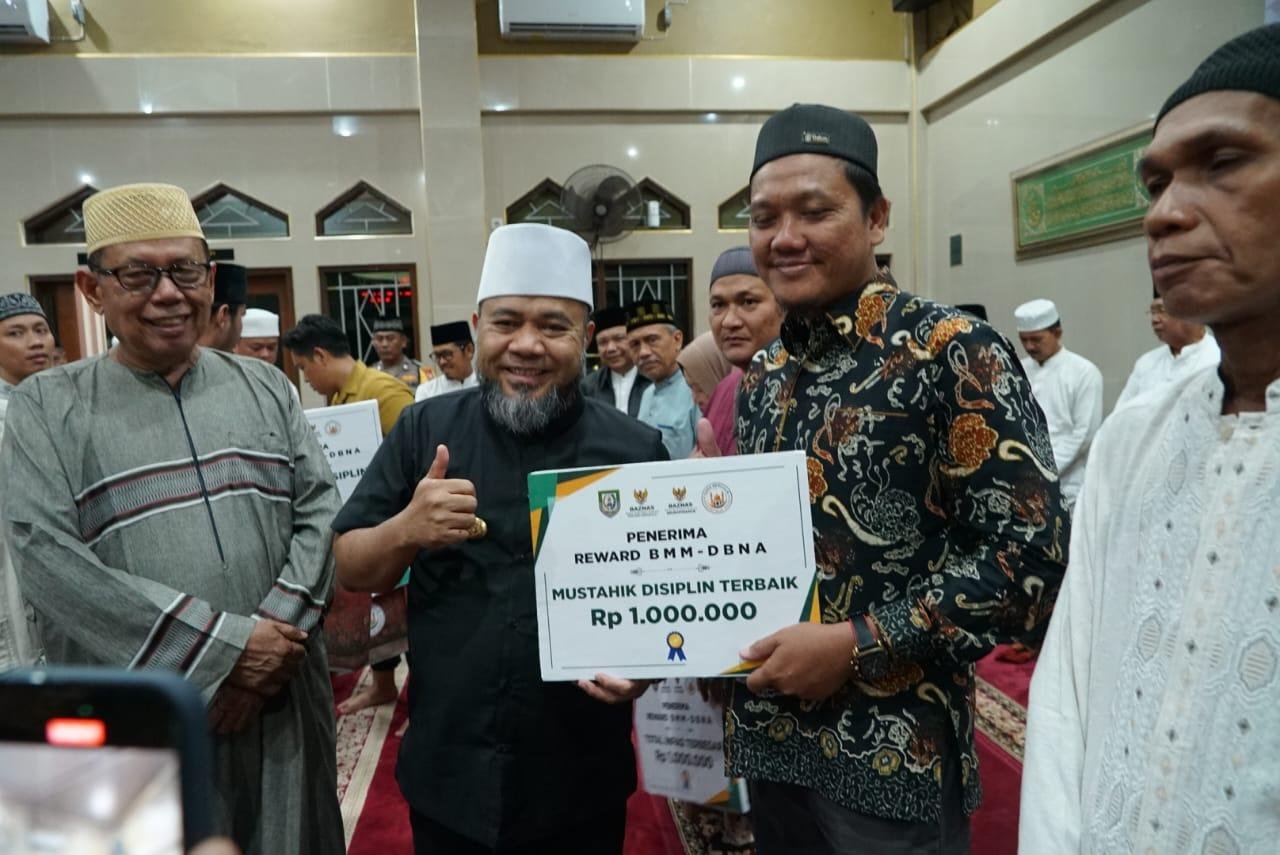 Reward dari Gubernur Bengkulu pengurus masjid Gubernur Bengkulu, Helmi Hasan disaksikan Rektor Universitas Negeri Islam Fatmawati Soekarno Bengkulu, Zulkarnain Dali (kanan) memberikan reward kepada belasan mustahik yang dinilai disiplin berinfaq.(Foto/Ist)