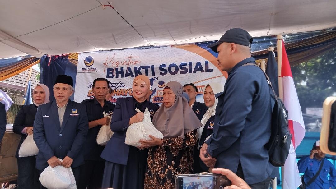 Ketua DPW Partai Nasdem Provinsi Bengkulu, Erna Sari Dewi (ESD) menyerahkan bantuan sembako kepada salah seorang simpatisan Nasdem pada acara puncak HUT Nasdem ke-14 tahun 2025, di Kantor DPW NasDem Provinsi Bengkulu, Selasa 11 November 2025.(Foto HB/Usmin)