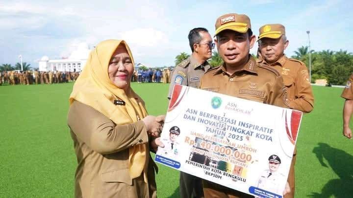 Wali Kota Bengkulu, Dedy Wahyudi menyerahkan hadiah Umroh kepada ASN Pemkot Bengkulu yang berprestasi senilai Rp 40 juta. Hadiah ini diberikan sebagai apresiasi atas kinerja dan prestasi serta didiikasi sebagai ASN dalam melayani masyarakat.(Foto/Ist)