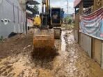 Alat berat jenis excavator bekerja membersihkan lumpur yang terbawa saat banjir lalu. Upaya ini dilakukan untuk membuka akses agar aktivitas masyarakat kembali normal.(Foto/Komdigi)