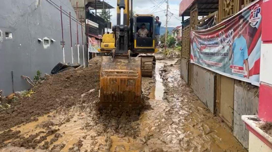 Alat berat jenis excavator bekerja membersihkan lumpur yang terbawa saat banjir lalu. Upaya ini dilakukan untuk membuka akses agar aktivitas masyarakat kembali normal.(Foto/Komdigi)