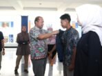 Rektor Unib, Indra Cahyadinata memasangkan jaket kepada salah seorang mahasiswa yang akan melaksanakan KKN di daerah bencana banjir Sumbar pada acara pelepasan pemberangkatan di kampus Unib, Rabu 17 Desember 2024.(Foto/Ist)