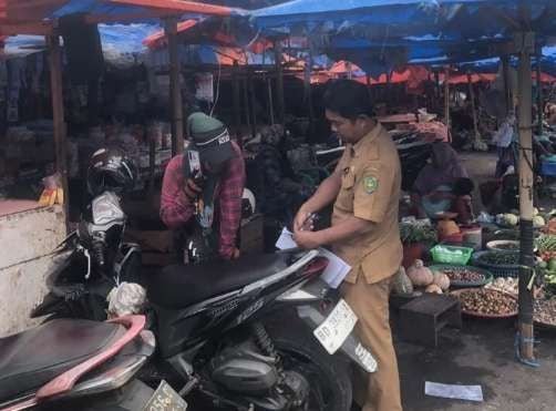 Tertibkan Jukir Salah seorang petugas dari Bapenda Kota Bengkulu mengecek surat tugas kepada petugas parkir sebagai upaya menertibkan jukir ilegal di daerah ini.(Foto/Ist)