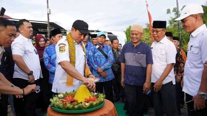 Wali Kota Bengkulu, Dedy Wahyudi memotong nasi tempung saat menghadiri syukuran warga Kopmlek Perum Griya Andikan di Kelurahan Sumur Dewa, Kecamatan Selebar atas selesai pembangunan jalan aspal hotmix di komplek tersebut.(Foto/Ist)