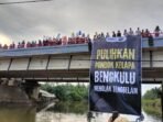 Ratusan warga Desa Pondok Kelapa, Kabupaten Bengkulu Tengah melakukan aksi benteng spanduk di atas jembatan sebagai aksi protes atas abrasi di desa mereka belum mendapat perhatian dari pemda setempat.(Foto/Walhi)