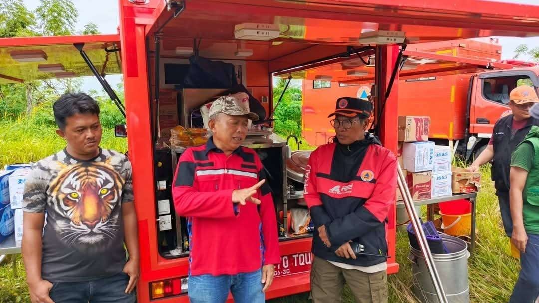 Plt Sekda Kota Bengkulu, Tony Alfian tengha berdiskusi dengan Kepala BPBD Kota Bengkulu, I Made Arwana dibelakang mobil daput umum di salah satu lokasi banjir di wilayah ini.(Foto/Ist)